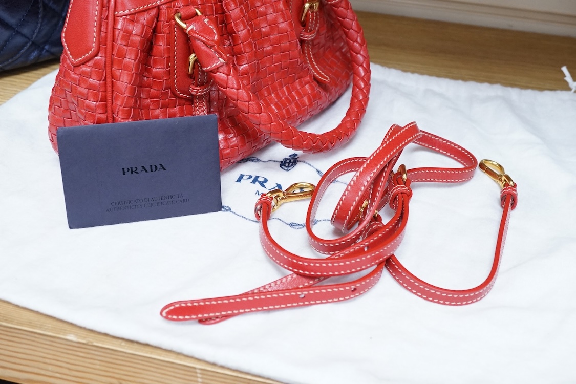 A Prada red braided leather handbag with shoulder strap, authenticity card and dust cover, 25cm wide, Provenance: Purchased by the vendor in Selfridges